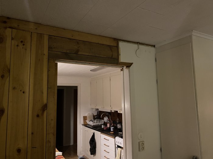 Bärande vägg delvis rivet för att visa ytskikt i köksrenoveringsprojekt.