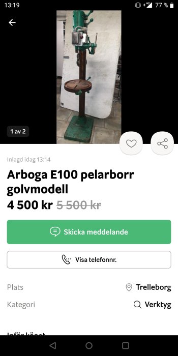 Grön Arboga E100 pelarborr, golvmaskin står i verkstad, med prisangivelse och kontaktinformation.