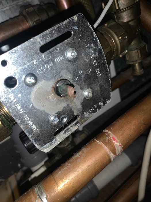 Närbild av en justerad shunt för golvvärmesystem, med rördetaljer och mekaniskt reglage.