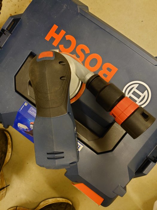 Adapter ansluten till en Bosch slipmaskin ovanpå en Festool dammsugare med synliga måttangivelser.