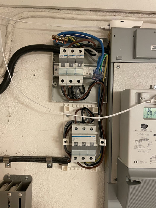 Elcentral med säkringar och ledningar, inklusive blå nolla och gul/grön jord i installationsmiljö.