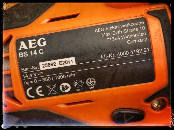 Nahaufnahme eines AEG BS 14 C Schraubendrehers mit erkennbaren Spezifikationen und der Seriennummer auf einem Typenschild.
