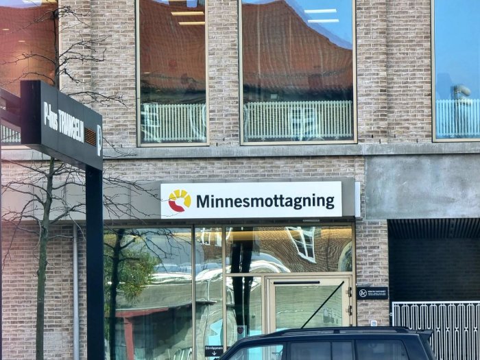 Skylt med texten "Minnesmottagning" på en byggnadsfasad.