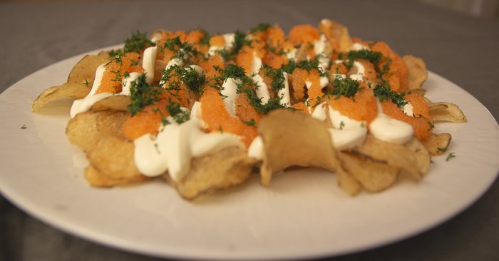 Tallrik med lantchips toppade med löjrom, crème fraîche och dill.