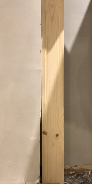 Spacklad betongvägg med en trälist som visar ojämnheter efter borttaget och igenmurat fönster.