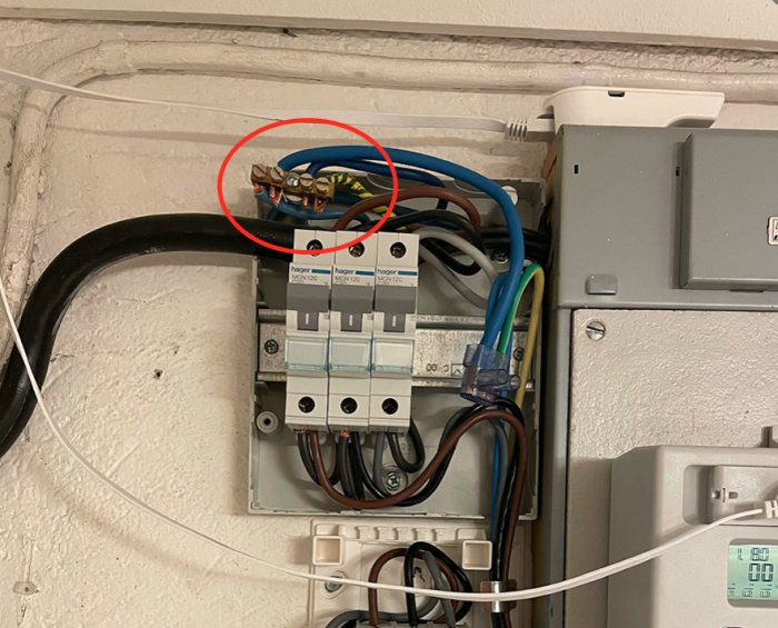 Elektrisk central med en plint där noll och jord från en 5-ledarkabel är anslutna, inringad i rött.