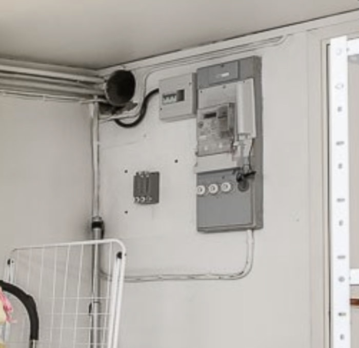 Elcentral med mätare och säkringar, och en kabelansluten plint.