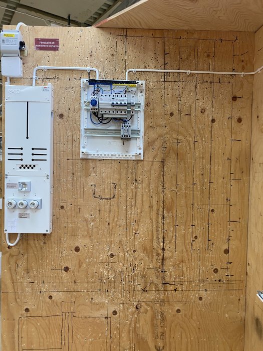 Ny kabeldragning och installerad kontaktor med skymningsrelä på trävägg i teknikrum.