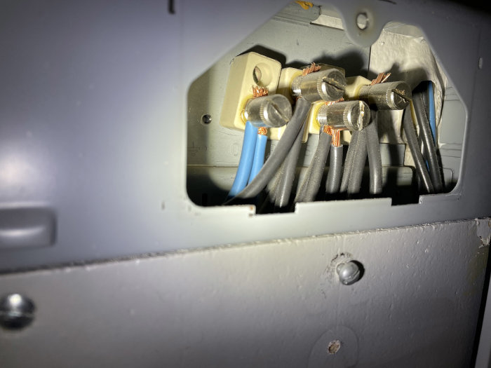 Elektriska kablar och kopplingar i en elcentral med öppen lucka som visar tre faser och en PEN-ledare.