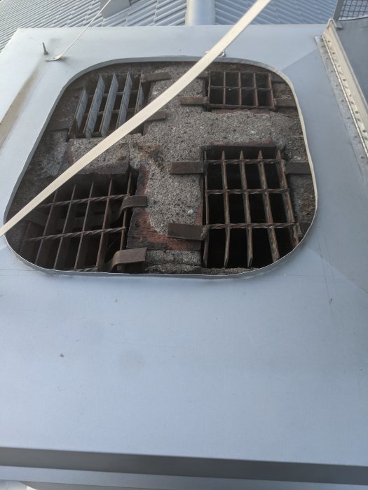 Öppning i en murad skorsten med synliga kanaler som kan vara en ledig plats för en kamininstallation.