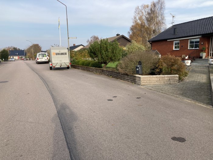 Ren tvättad stenmur framför hus i bostadsområde.