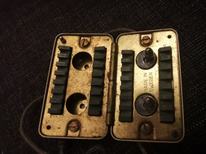 Gammal hopvikt metallisk dosa med texten "MADE IN SWEDEN" och utskurna tandväxlar på övre sidan.