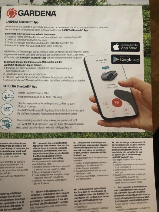 Hand håller information om GARDENA Bluetooth® App med bild av robotgräsklippare Sileno styrd via smartphone.