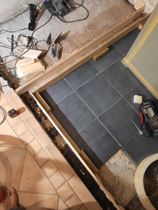 Byggform av trä för betonggjutning på ett renoveringsprojekt med verktyg omkring.
