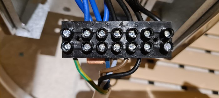 Elanslutningsplint med gammal trefaskabel och skyddsjordsledning i ett renoverat badrum.