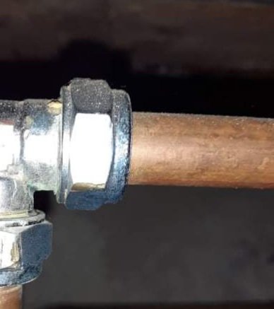 Kopparrör med klämring anslutet till en rördel, behöver byte eller reparation.
