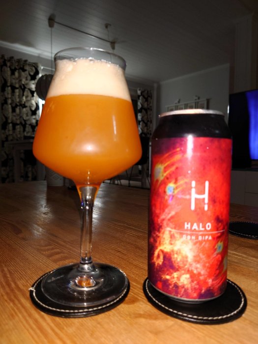 Ett glas öl och en burk med etiketten 'Halo' på ett bord, firande av husdjurets födelsedag.