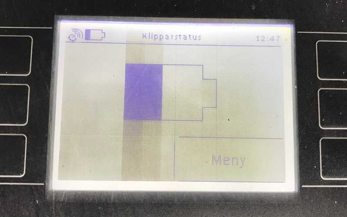 Display på en robotgräsklippares laddstation som visar status, indikerande laddning pågår.