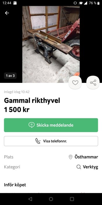 En gammal rikthyvel i en verkstad med en röd släpvagn i bakgrunden.