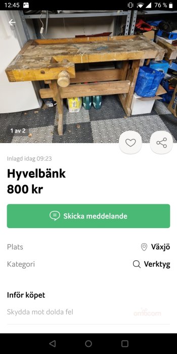 Använd hyvelbänk i en verkstad, placerad framför hyllor med verktyg och material.