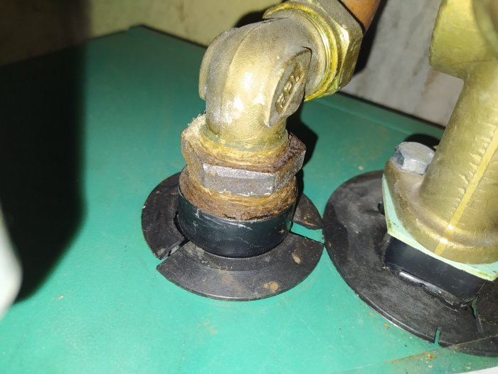 Närbild av korroderade rördelar och anslutningar i en värmepanna.