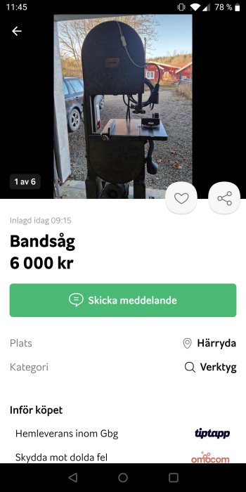 En bandsåg till salu för 6 000 kr placerad utomhus med en bil och röda byggnader i bakgrunden.