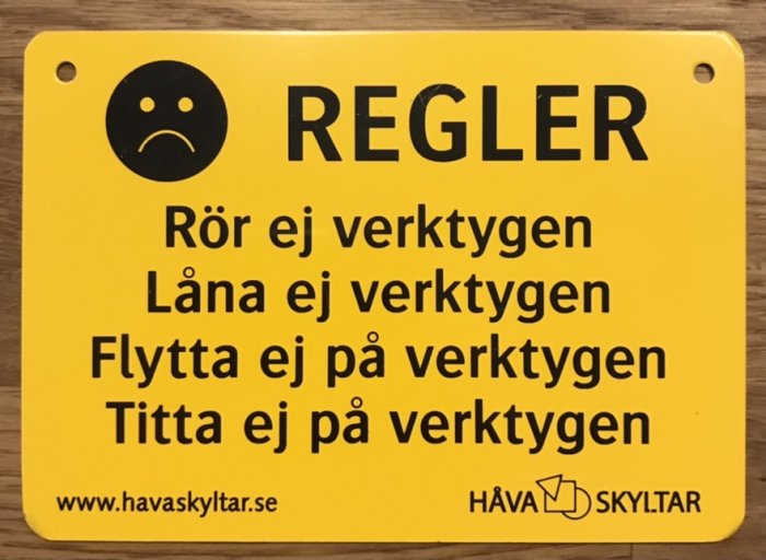 Gul skylt med texten "REGLER" och förmaningar om att inte röra, låna, flytta eller titta på verktygen.