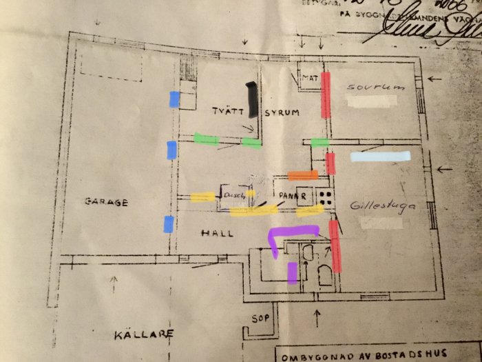 Planritning över en källare med markerade väggar i olika färger som indikerar potentiellt bärande strukturer i ett hus från 70-talet.