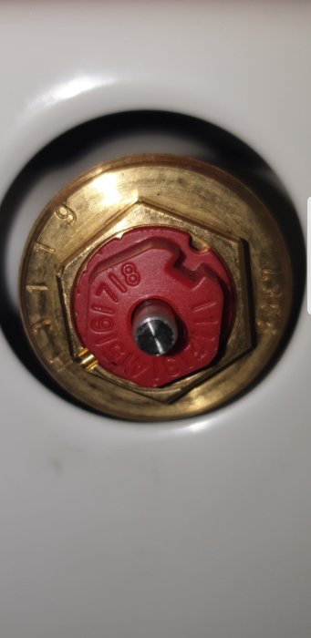 Närbild på en termostatventil till en radiator med synlig regleringsmekanism.