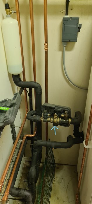 Värmepumpssystem med märkt filter, rör och ventiler i ett teknikrum.