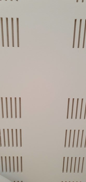 Tak med perforerade akustikplattor och misstänkt gipskonstruktion för projektorinfästning.