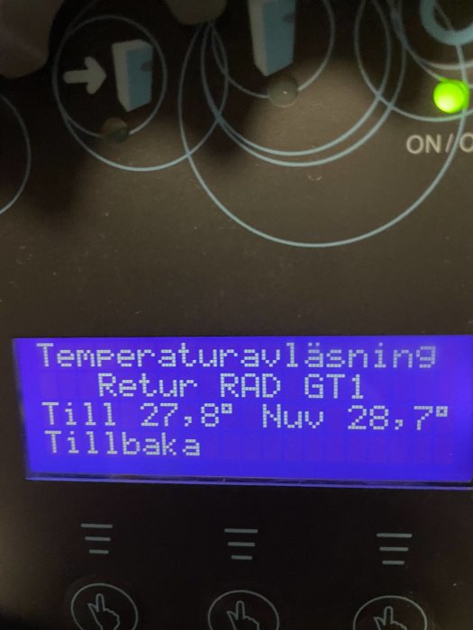 Display av bergvärmepump som visar temperaturavläsningar, med returtemperatur på 27,8°C och nuvarande temperatur på 28,7°C.
