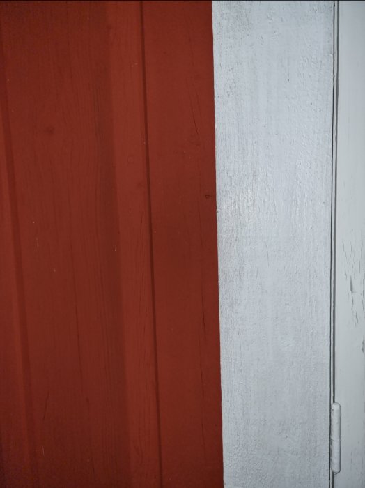 Närbild av röd och vit vägg med synlig väggfog och textur.