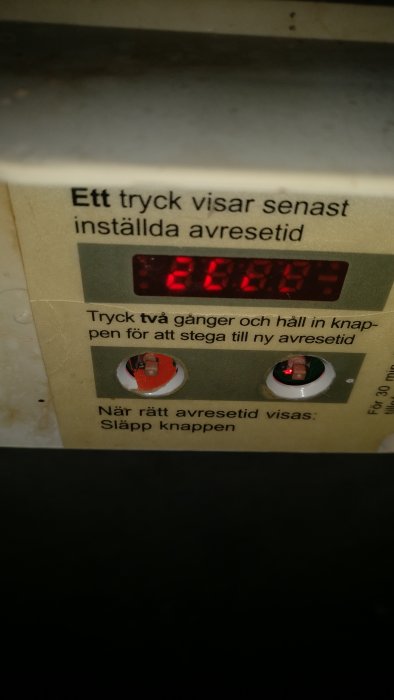 Digital timer med trasiga tryckknappshöljen och röd lysdiod, visar tiden 02:45.