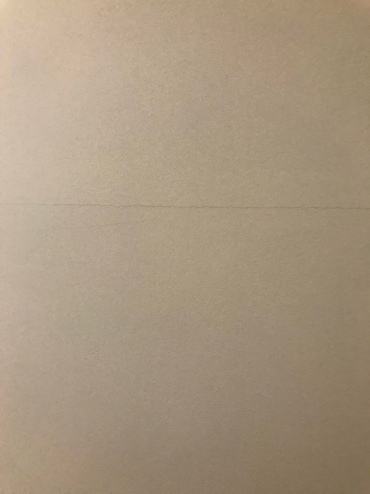 Spricka på nymålad vägg som avslöjar skarv mellan gipsskivor.
