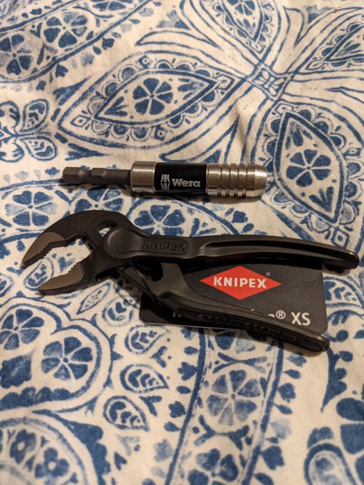 Wera bitshållare och Knipex Cobra XS vattenpumpstång på ett mönstrat tyg.