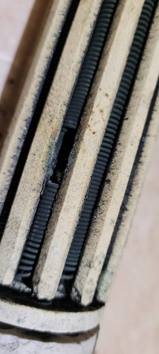 Närbild på sliten tätning i byggmaterial som visar tydliga tecken på användning och åldring.