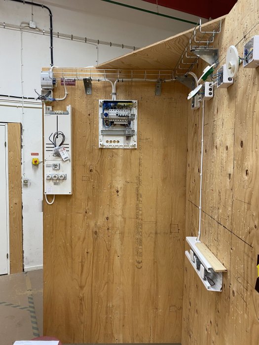 Installation för ETG-träning med kontaktor och tre kopplingsdon anslutna till tryckknappar på träpanel.