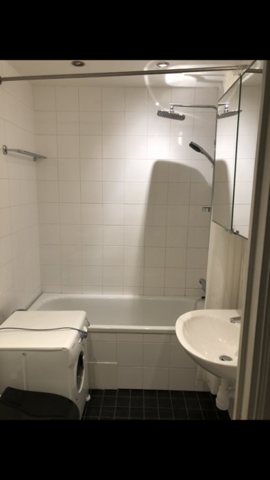 Badrum med sänkt tak för inbyggda spotlights, dusch, toalett och handfat.