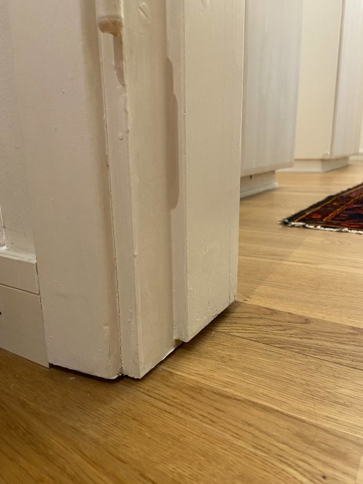 Dörrkarm som slutar ovanför ett trägolv där tidigare tröskel har tagits bort.