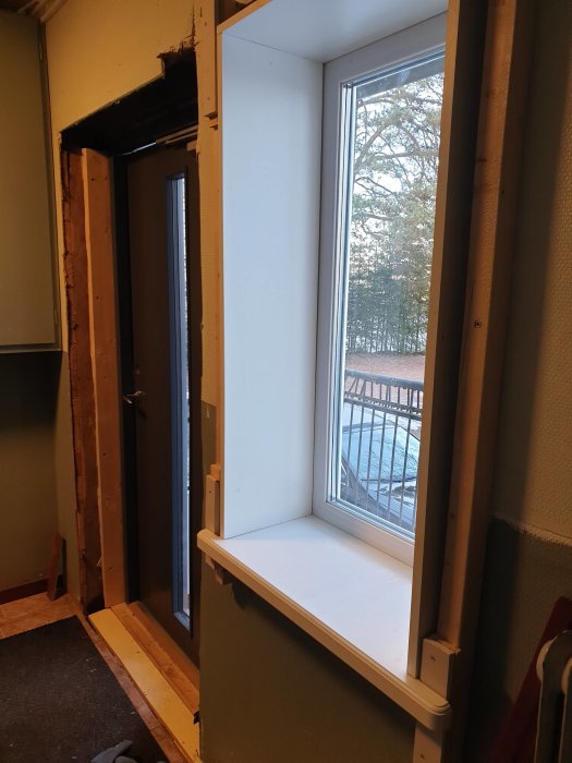 Nyligen installerad fönsterbänk och smyg i ett pågående renoveringsprojekt, med oskurna reglar synliga.
