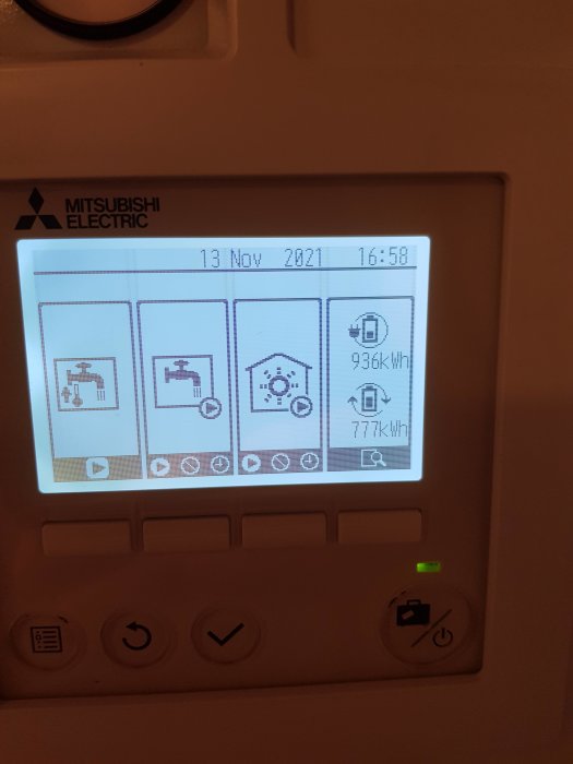 Display av en Mitsubishi Electric värmepump som visar energiförbrukning och datumet 13 Nov 2021.