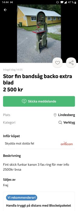 Äldre grön bandssåg framför en gul byggnad, till salu för 2 500 kronor.