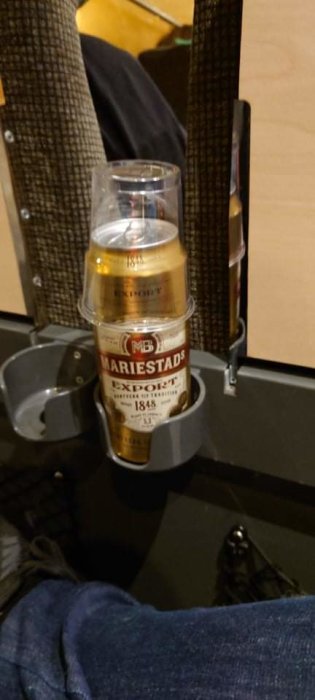 Ölburk av märket Mariestads Export placerad i ett tågsitsens muggställ.