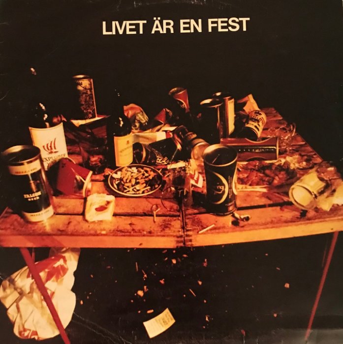 Bord täckt med rester efter en fest, inklusive tomma burkar, flaskor och smutsiga tallrikar. Texten "LIVET ÄR EN FEST" ovanför.