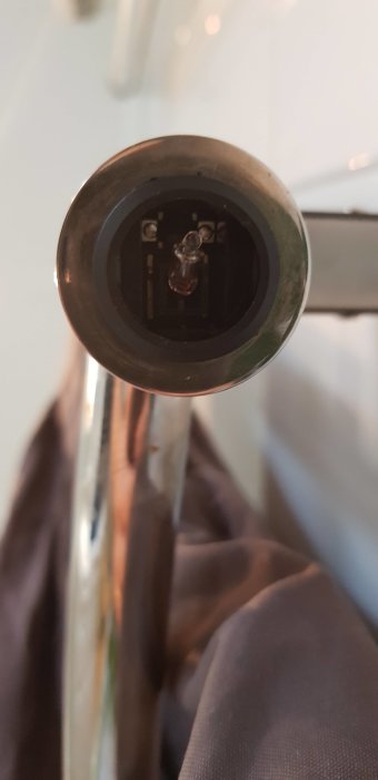 Sönder torkknapp på hånddukstork med synliga interna mekanismer och lösa stift.