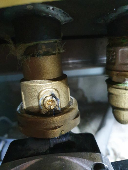 Ventil som läcker vatten under en panna, med synligt droppande från en cirkulär komponent.