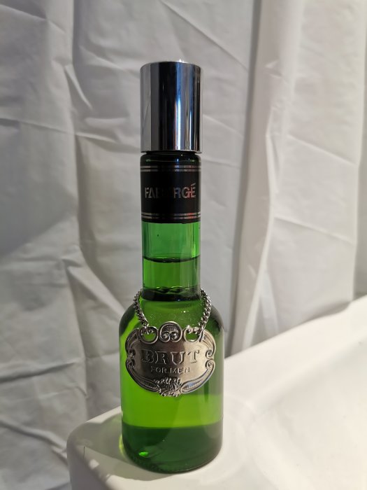 Oöppnad grön flaska parfym, Fabergé Brut för män, från 1980-talet står på vit yta.