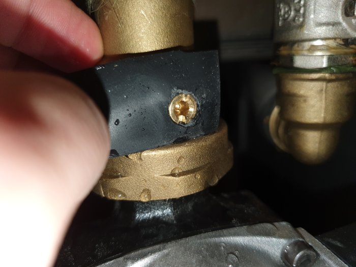 Närbild av en tätning med gummiduk och slangklämma vid röranslutning, kompletterad med bricka och metalldel.
