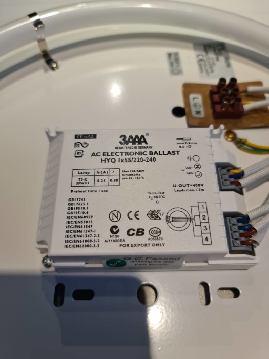 Elektronisk drivdon för lampa märkt "AC ELECTRONIC BALLAST" med teknisk specifikation och kablar synliga.